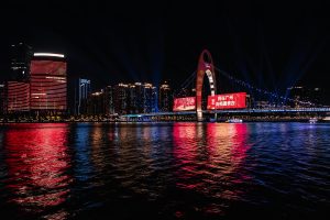 Stunning night view of Guangzhou skyline featuring illuminated buildings and bridge reflections on the river.